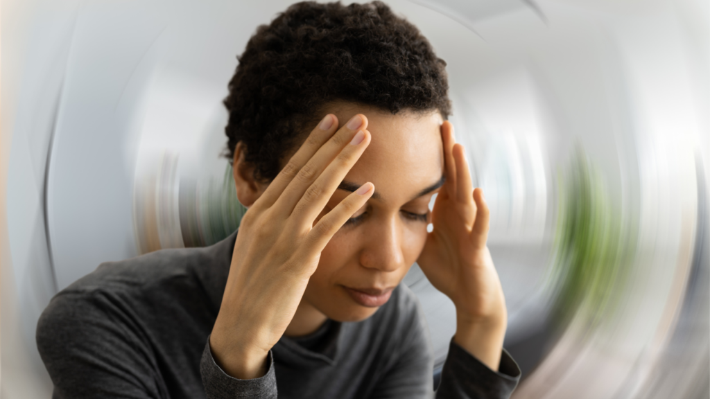 A medical-/executive-style photograph showing either a person experiencing dizziness or a clinician reviewing an MRI brain scan. Tone: professional, not overly dramatic.